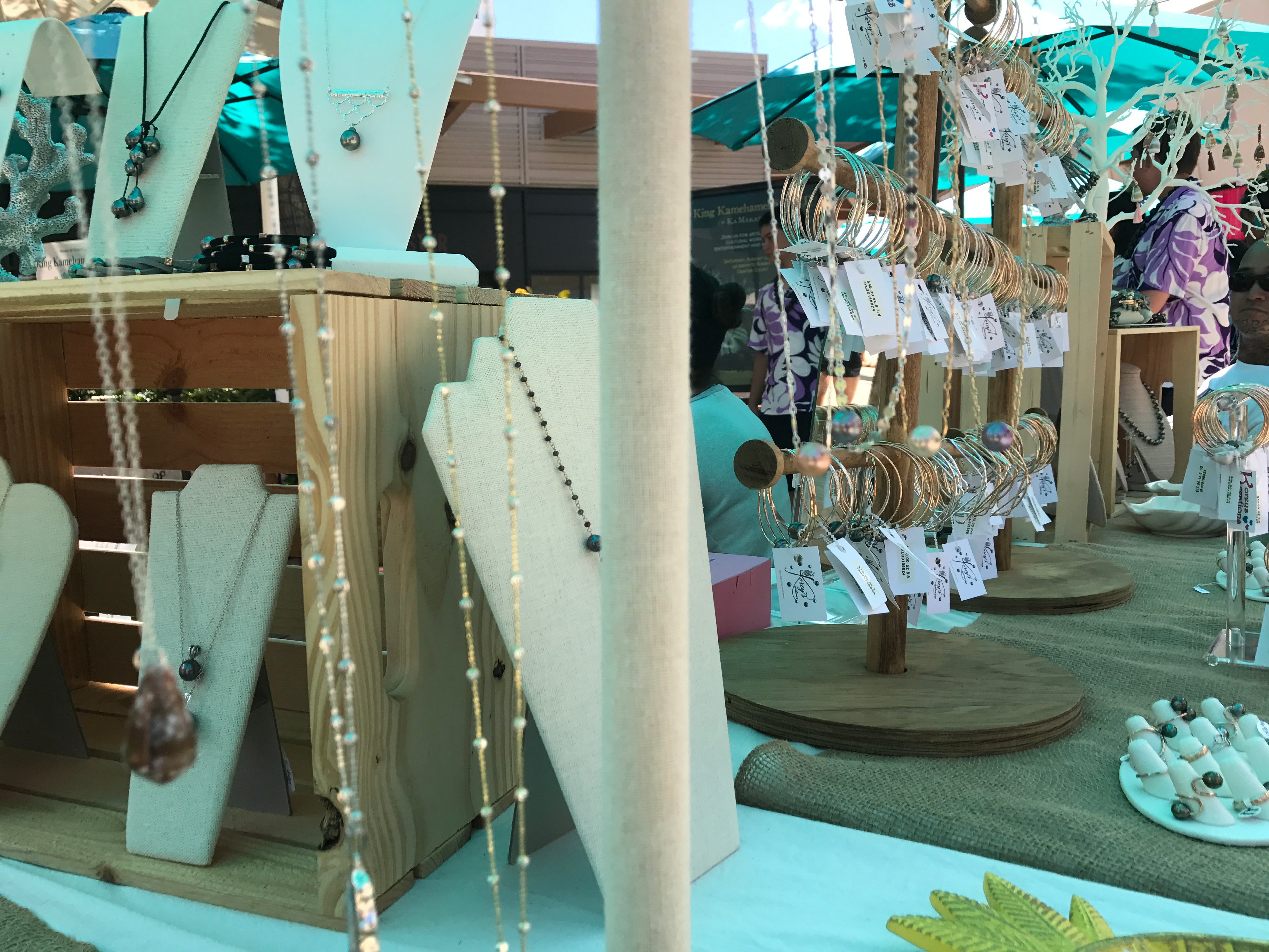 Turquoise jewelry booth with necklaces and bangles on wood displays