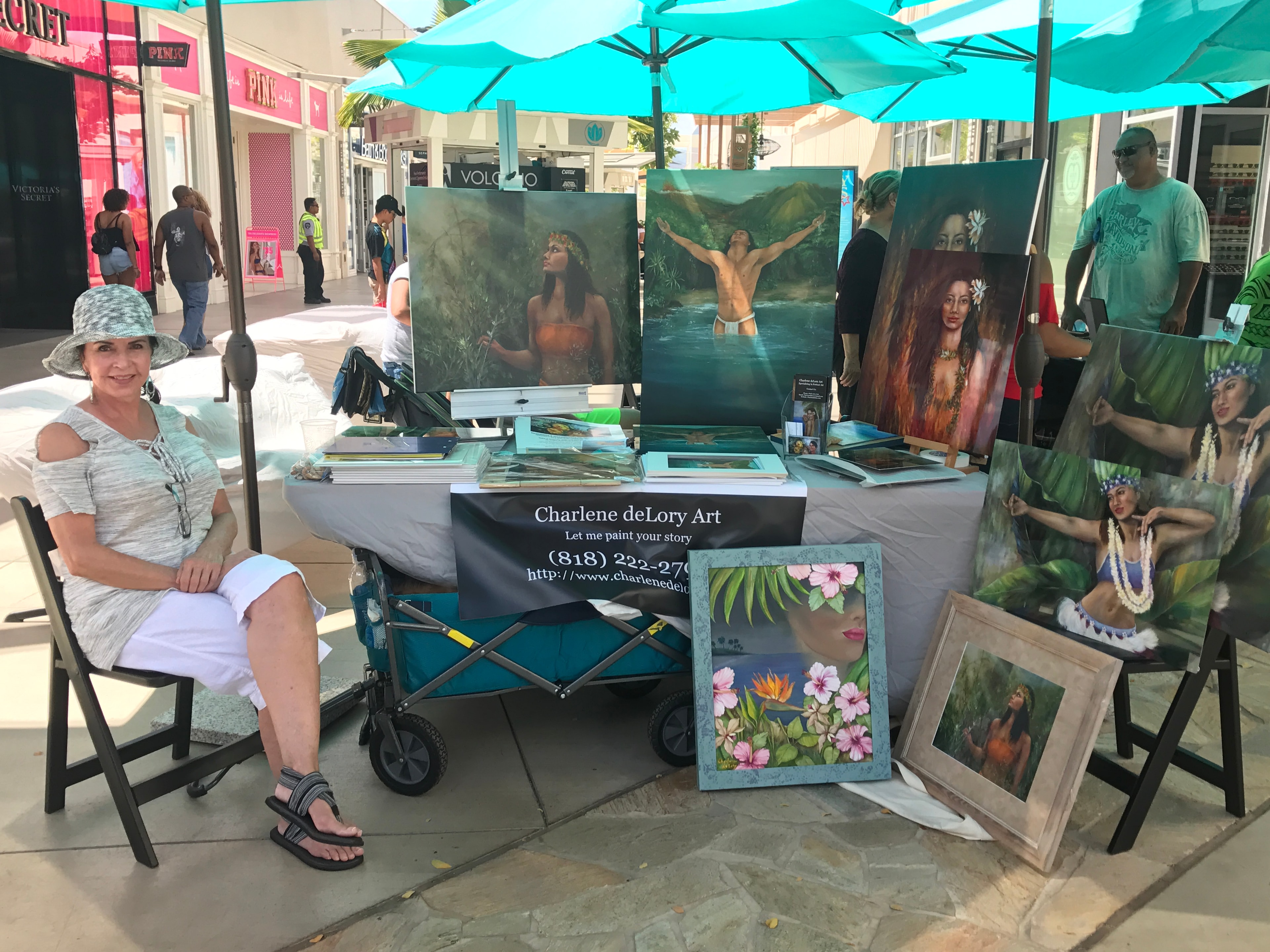 Charlene deLory Art booth with Hawaiian figurative paintings at outdoor market