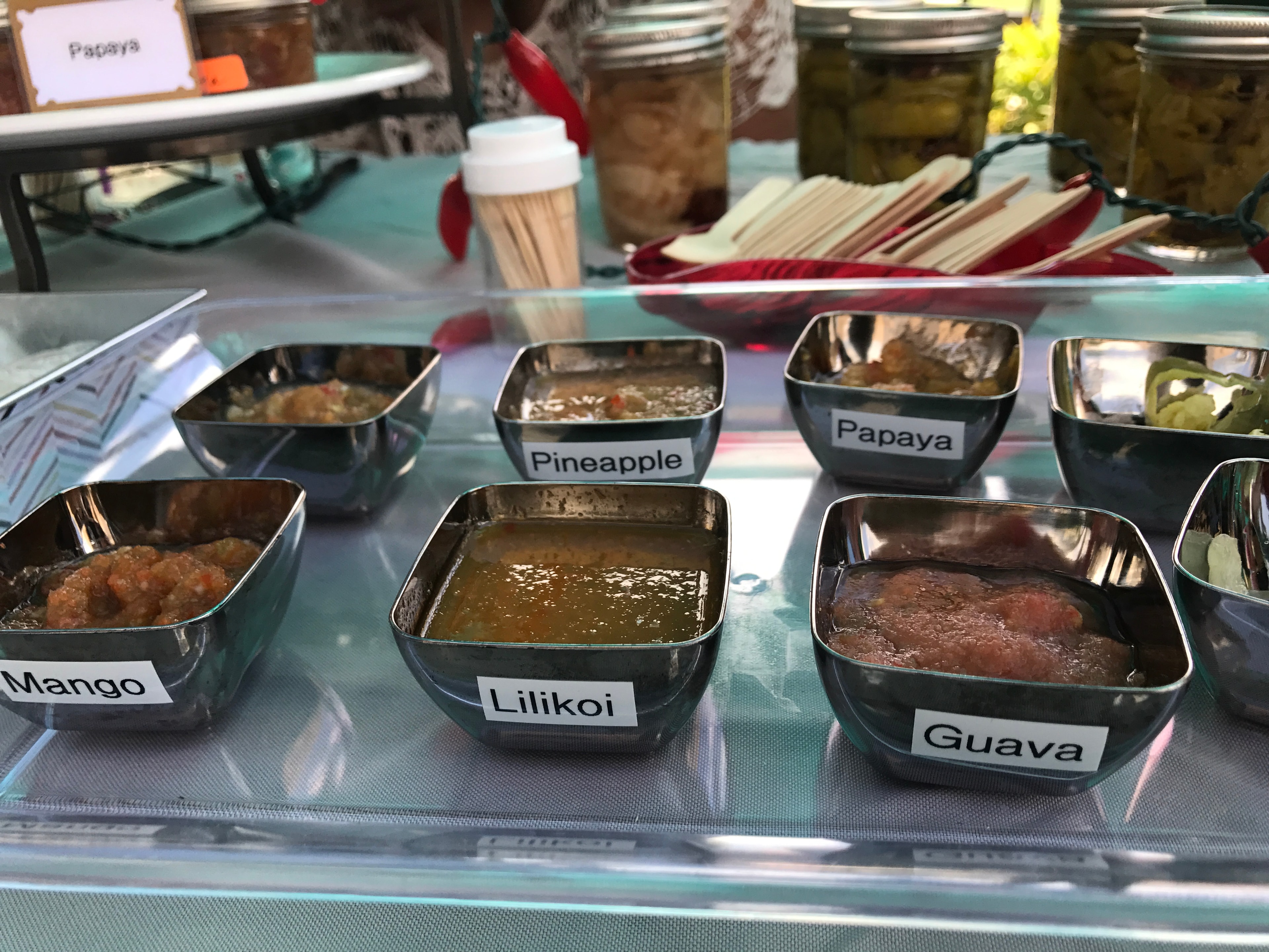Aunty Gwen's Tropical Infusion food samples in labeled bowls — mango, lilikoi, pineapple, papaya, guava