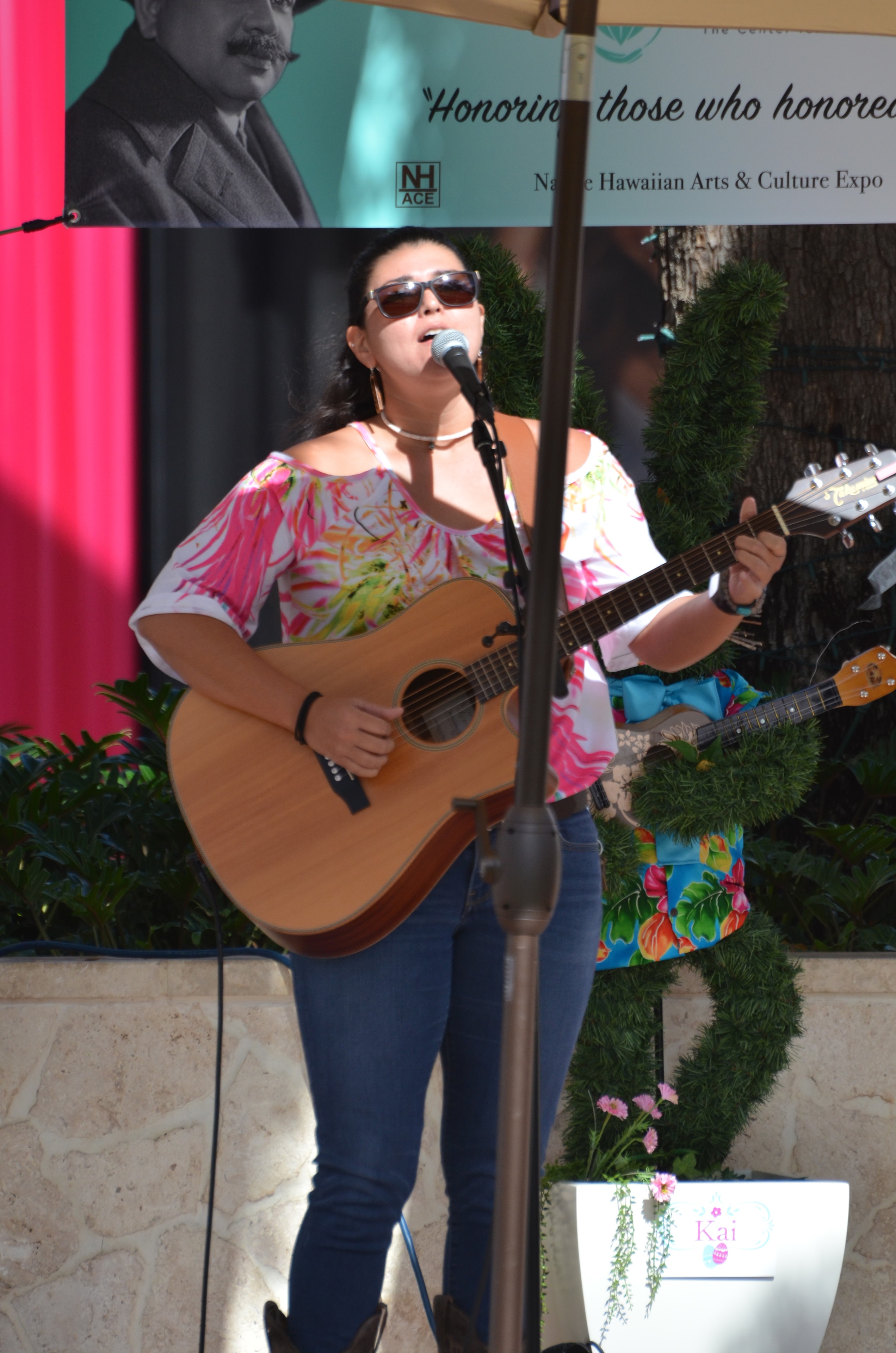 Woman performing acoustic guitar Hawaiian arts expo