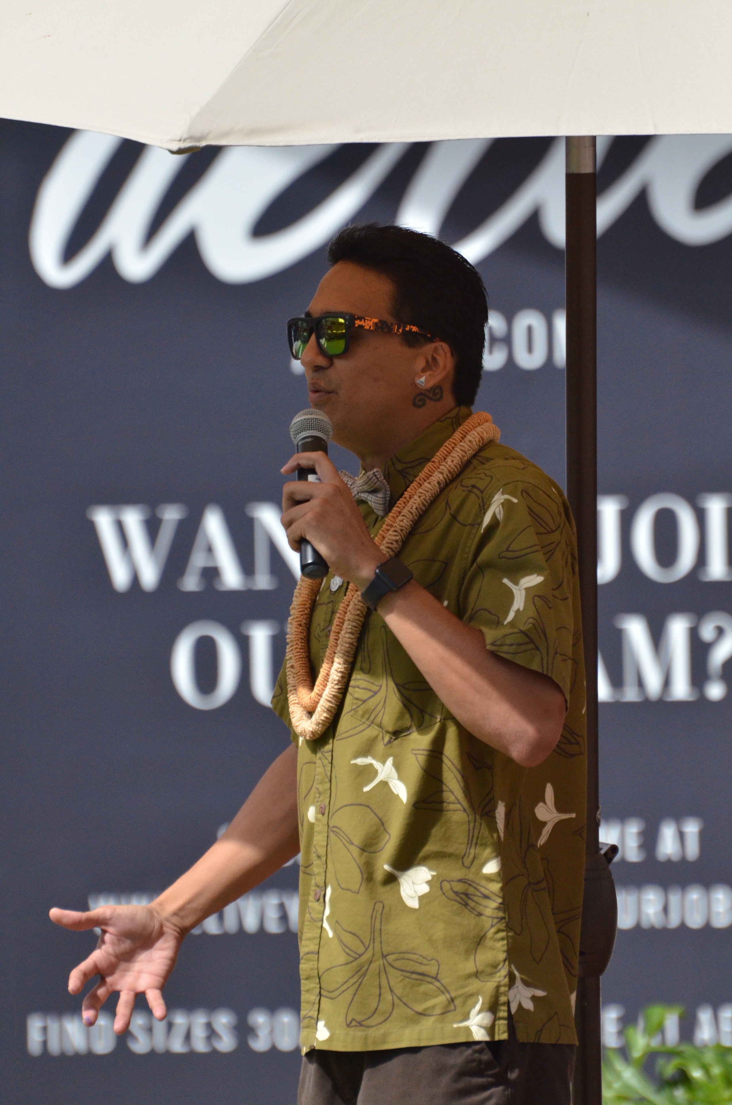 Man speaking into microphone at outdoor event