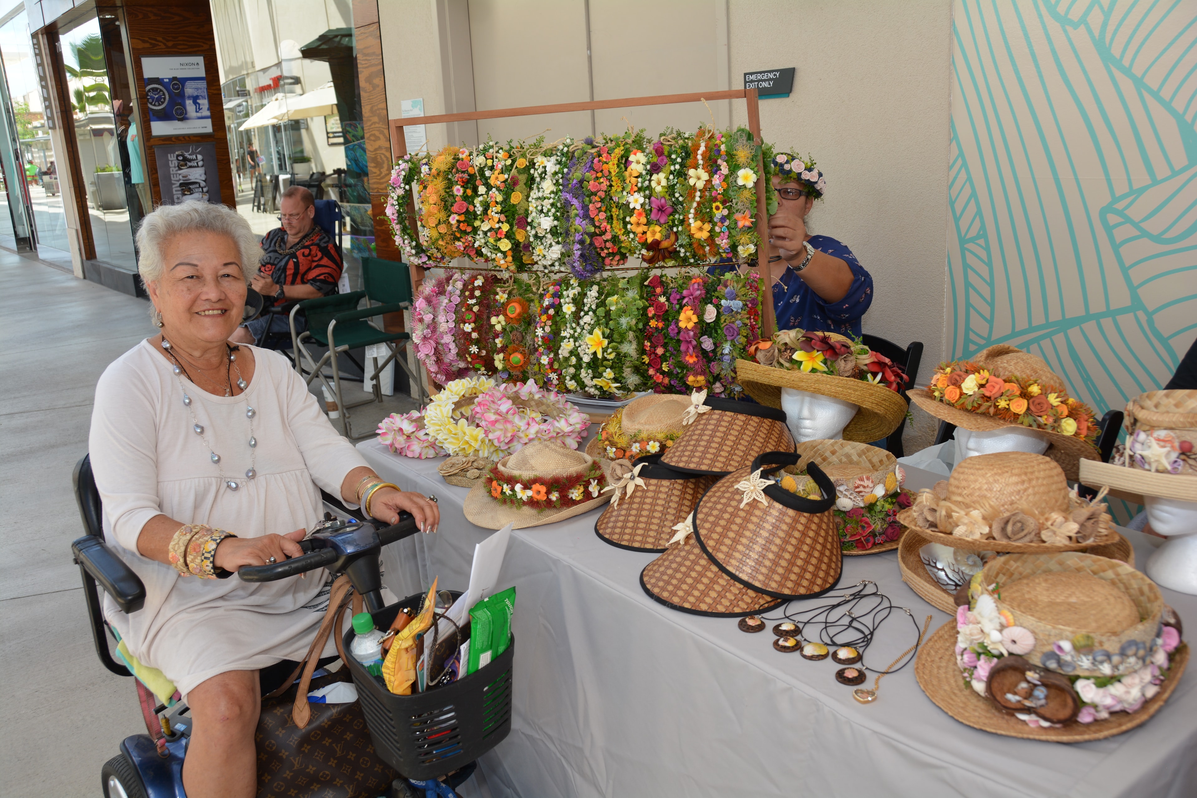 Woman selling flower decorated hats outdoors