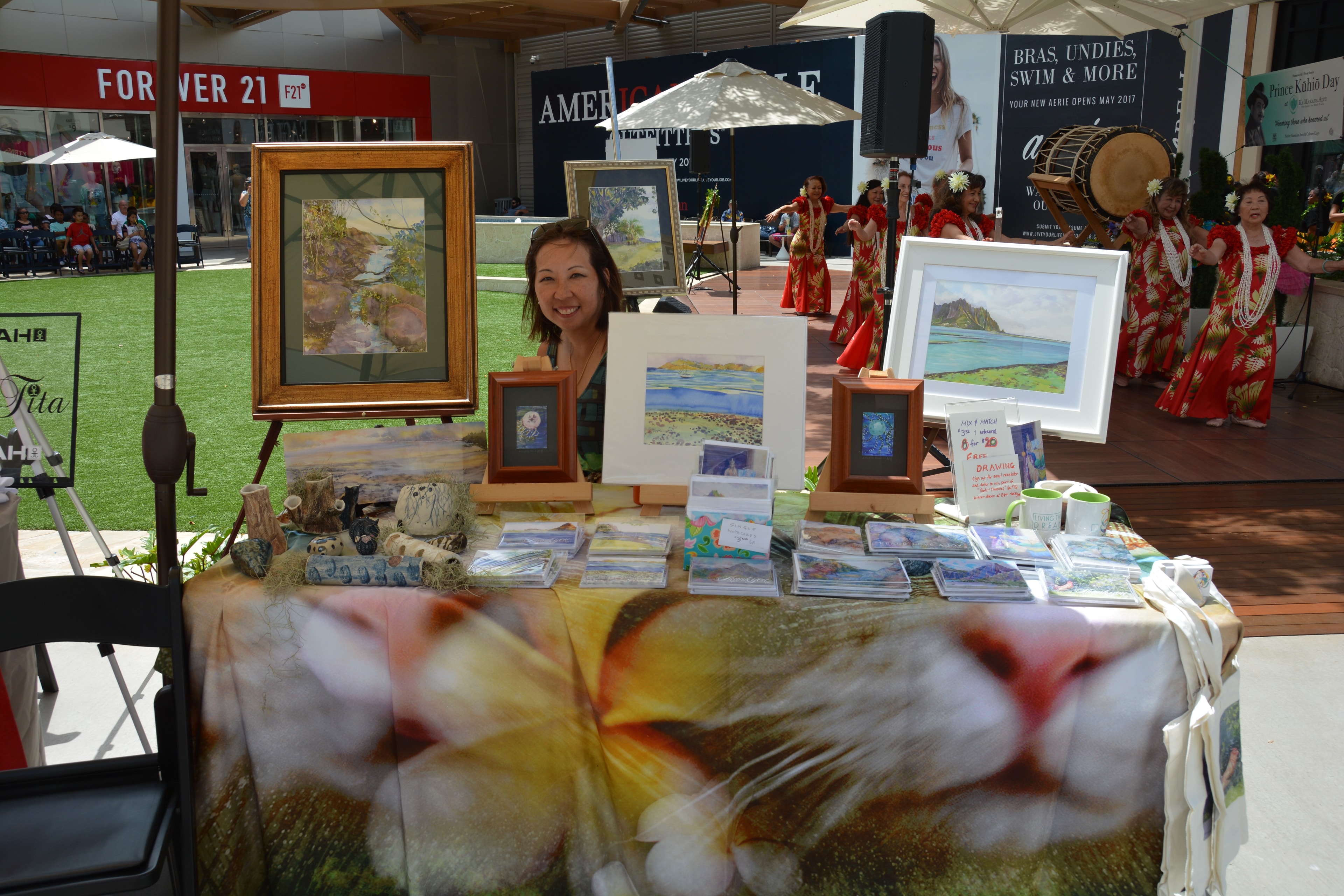 Artist displaying landscape paintings at outdoor event