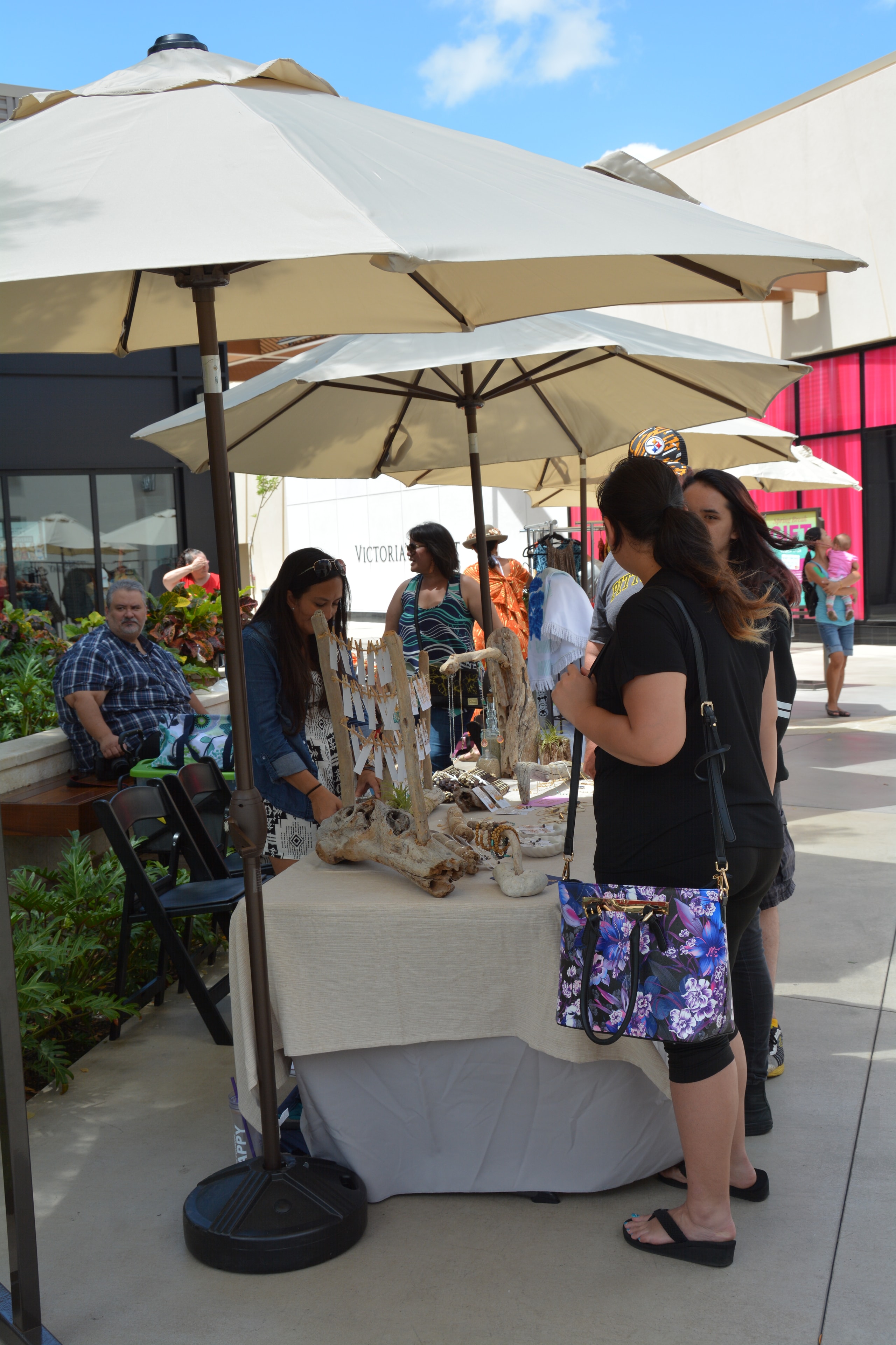 Outdoor market vendor booth shoppers browsing