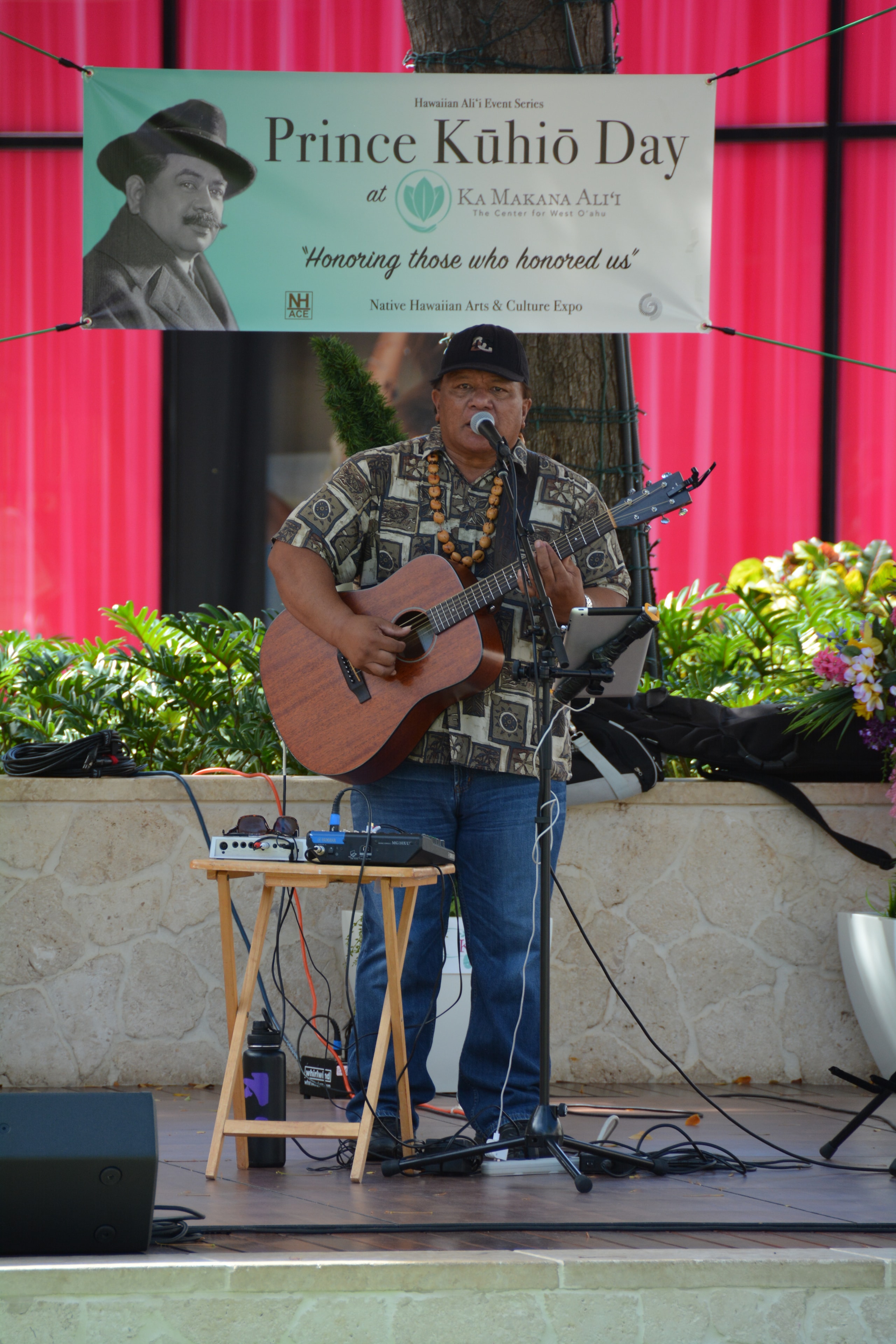 Musician performing guitar Prince Kūhiō Day event