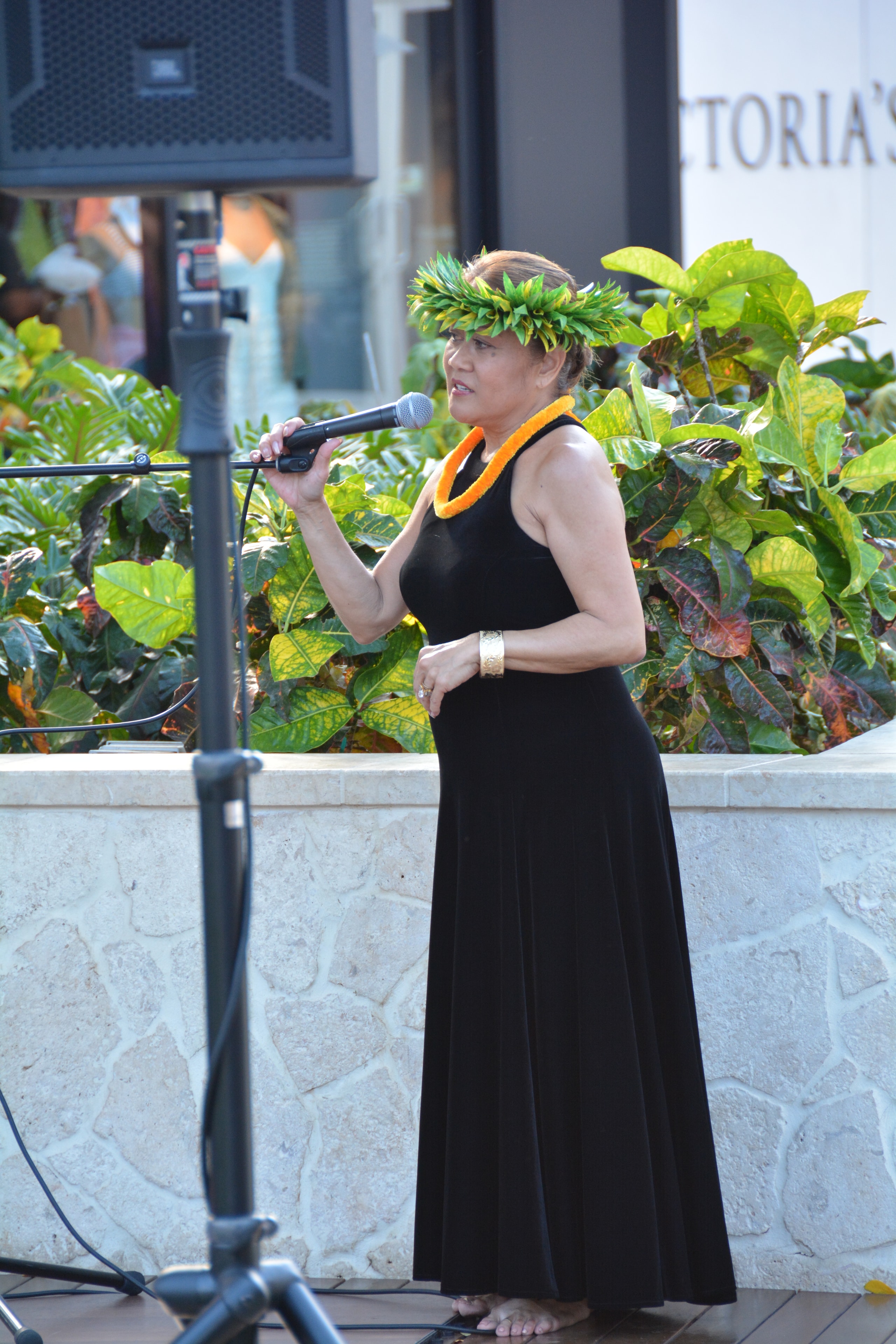 Woman singing microphone lei tropical plants