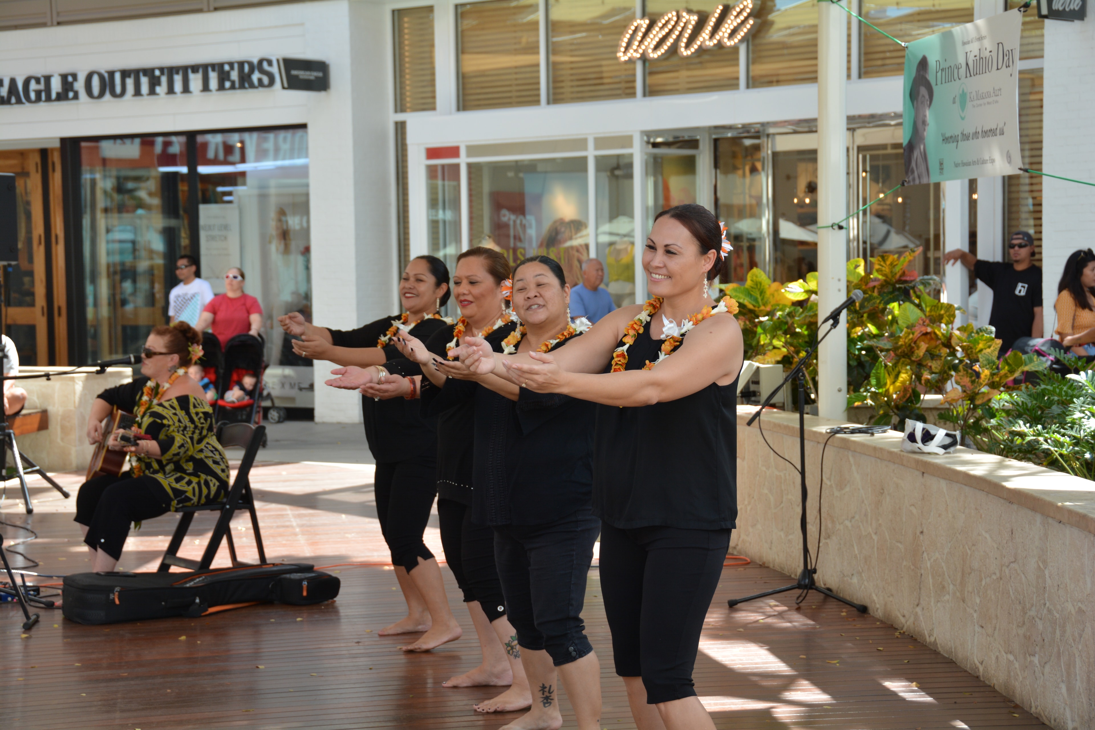 Hawaiian women dancers performing hula with arms extended at Prince Kūhiō Day