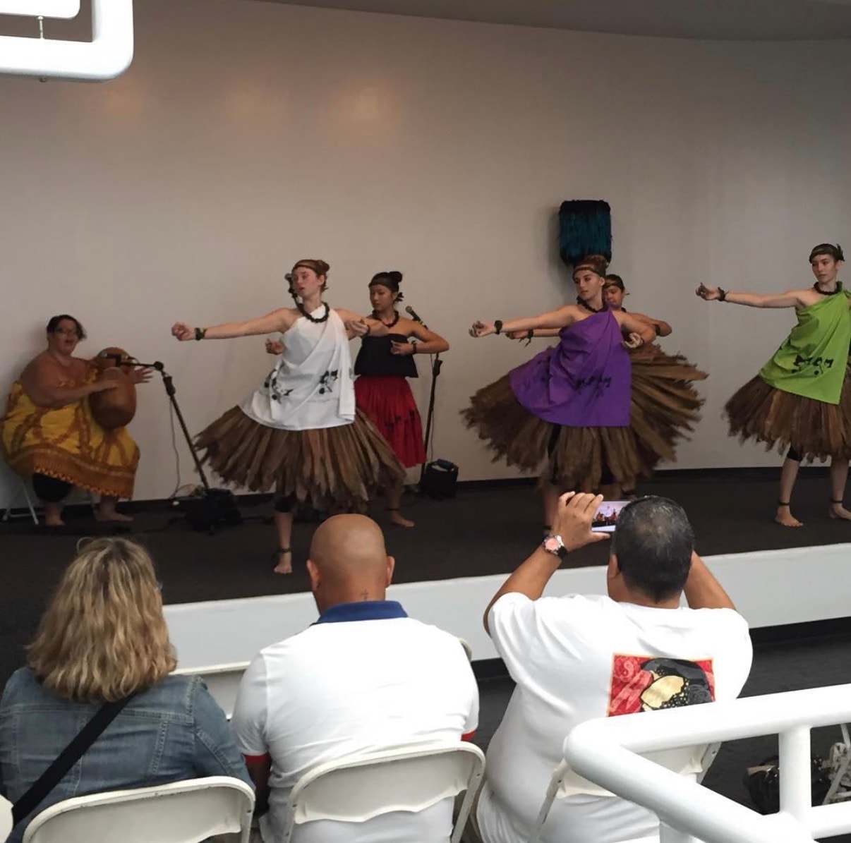 Performers dancing hula skirts on stage