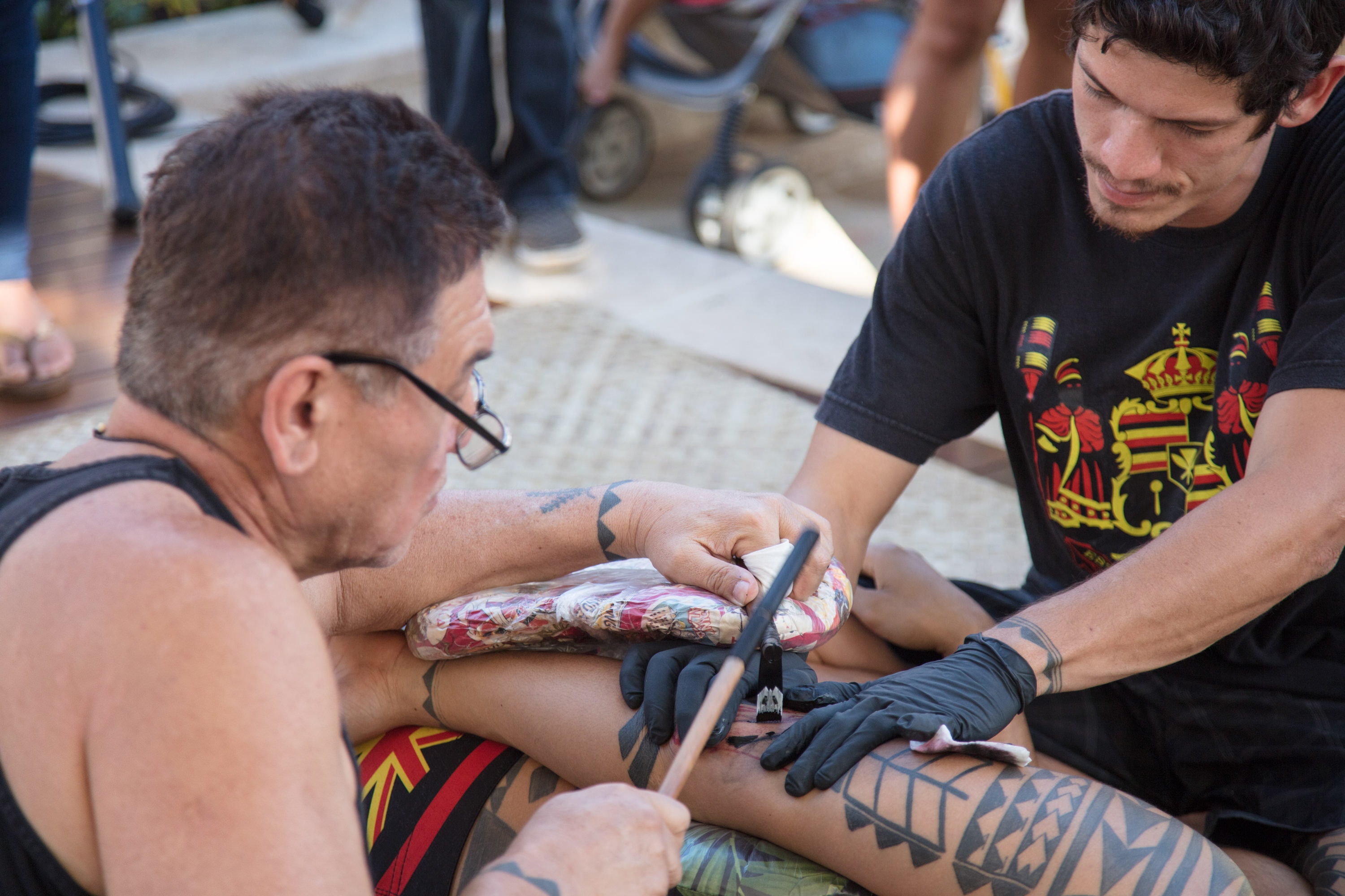Tattoo artist applying indigenous design on arm