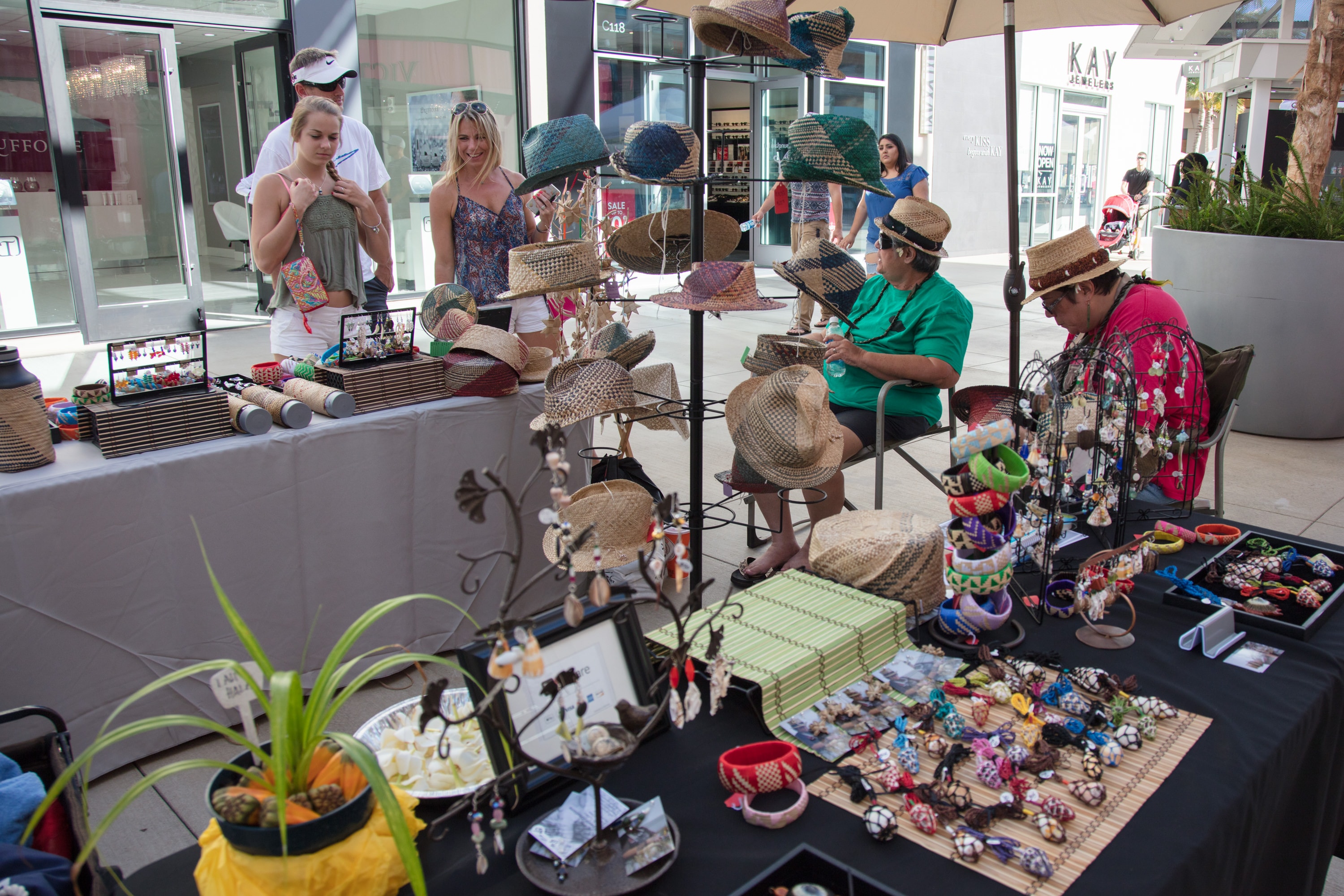 Outdoor market stall selling handmade crafts and hats