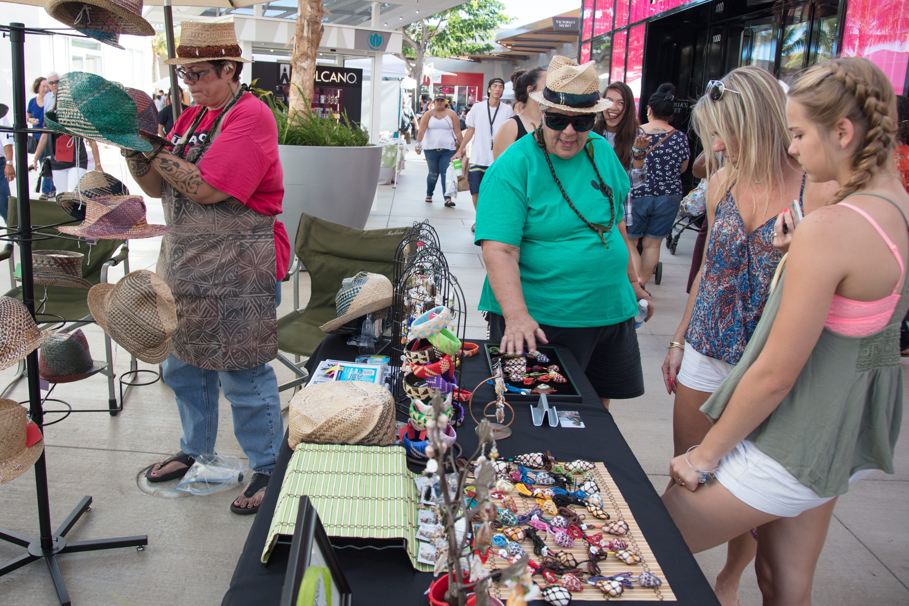Vendors selling hats and crafts at market