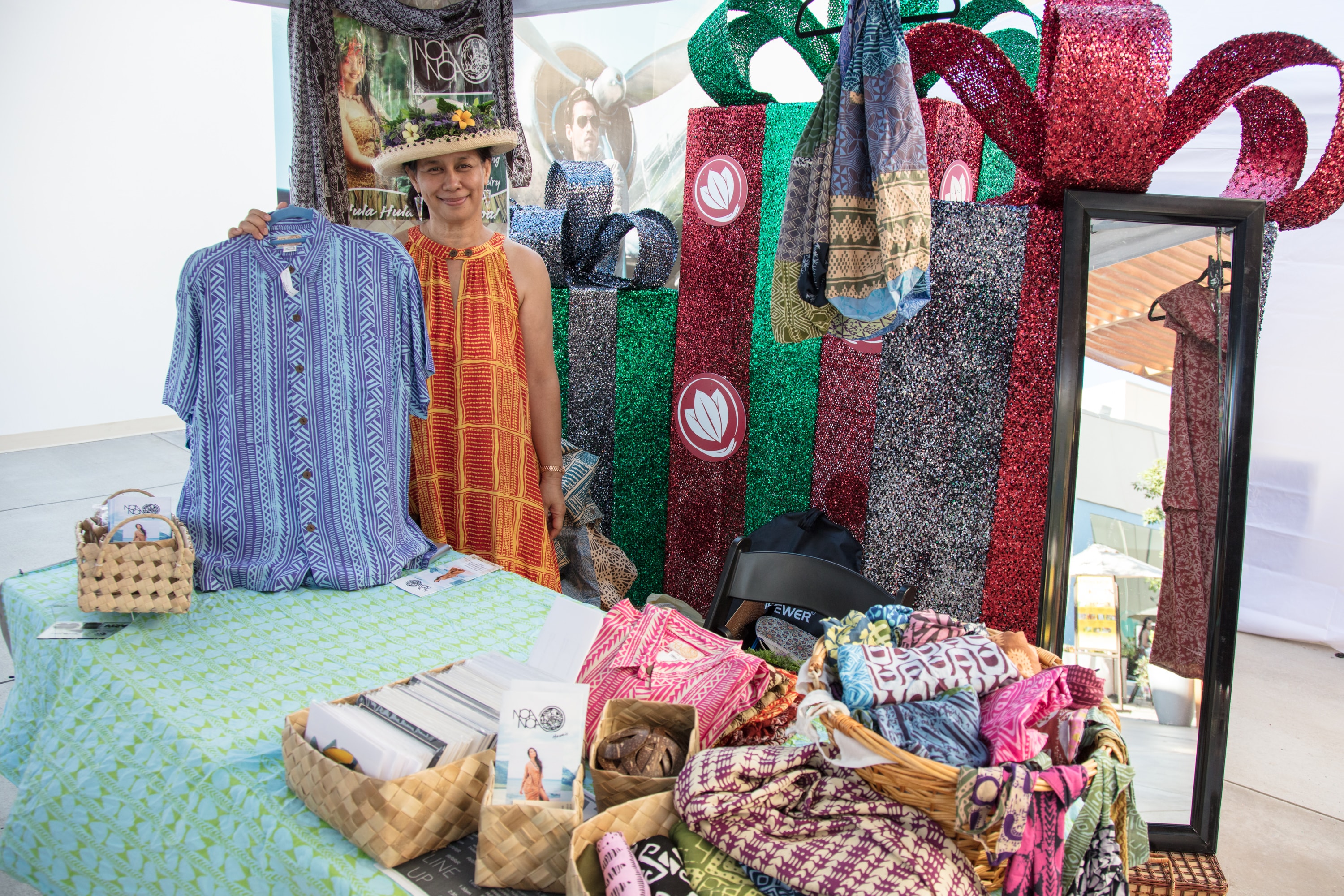 Vendor displaying colorful patterned clothing booth