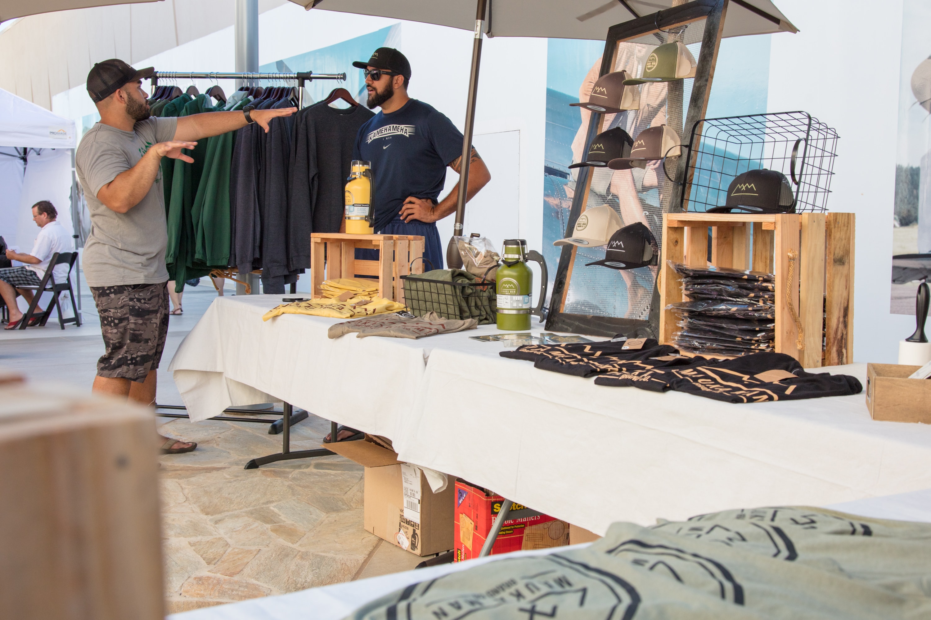 Outdoor vendor booth displaying clothing and merchandise