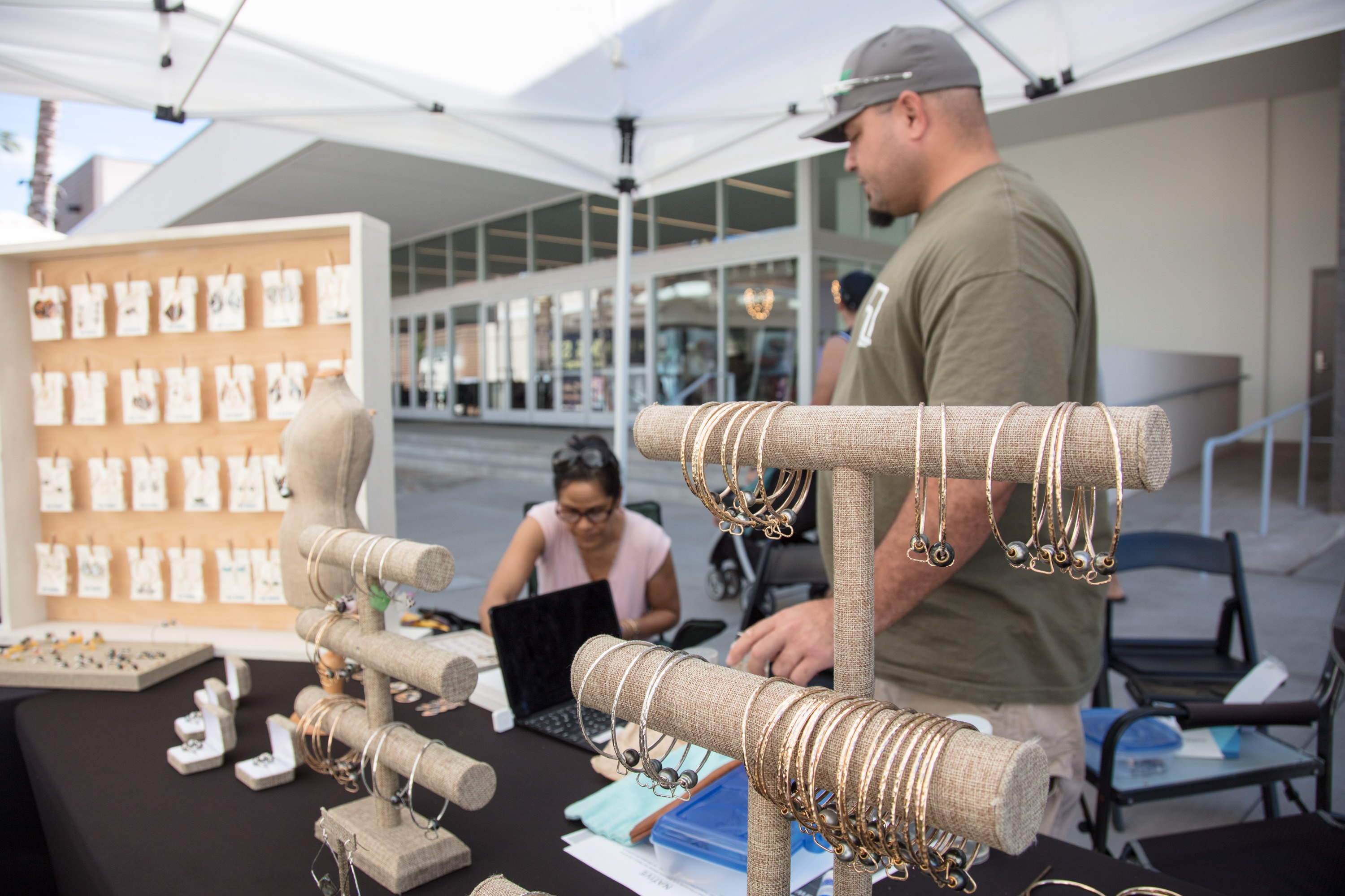 Jewelry vendor displaying bracelets at market booth