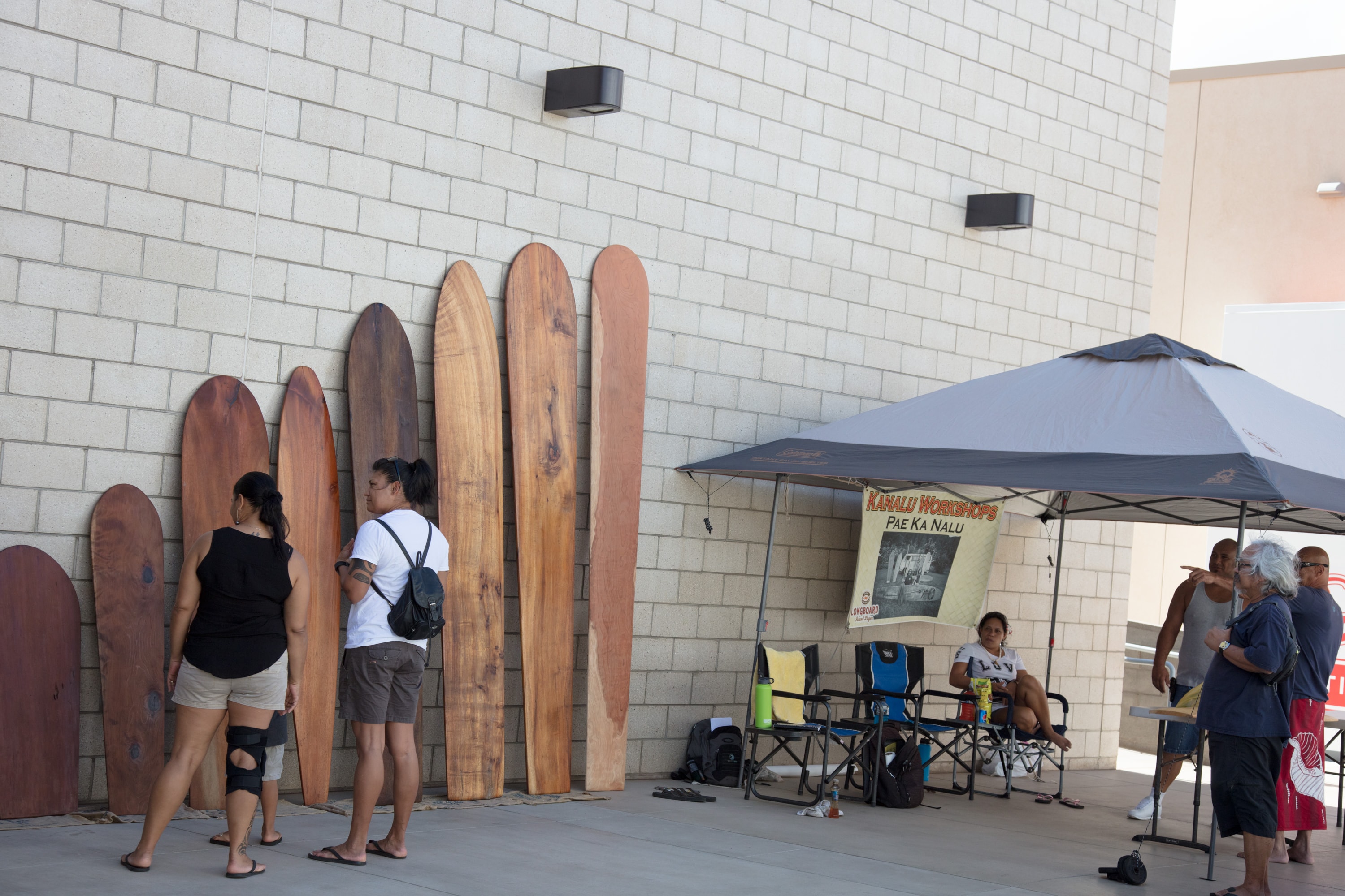 Surfboards displayed against brick wall outdoor event