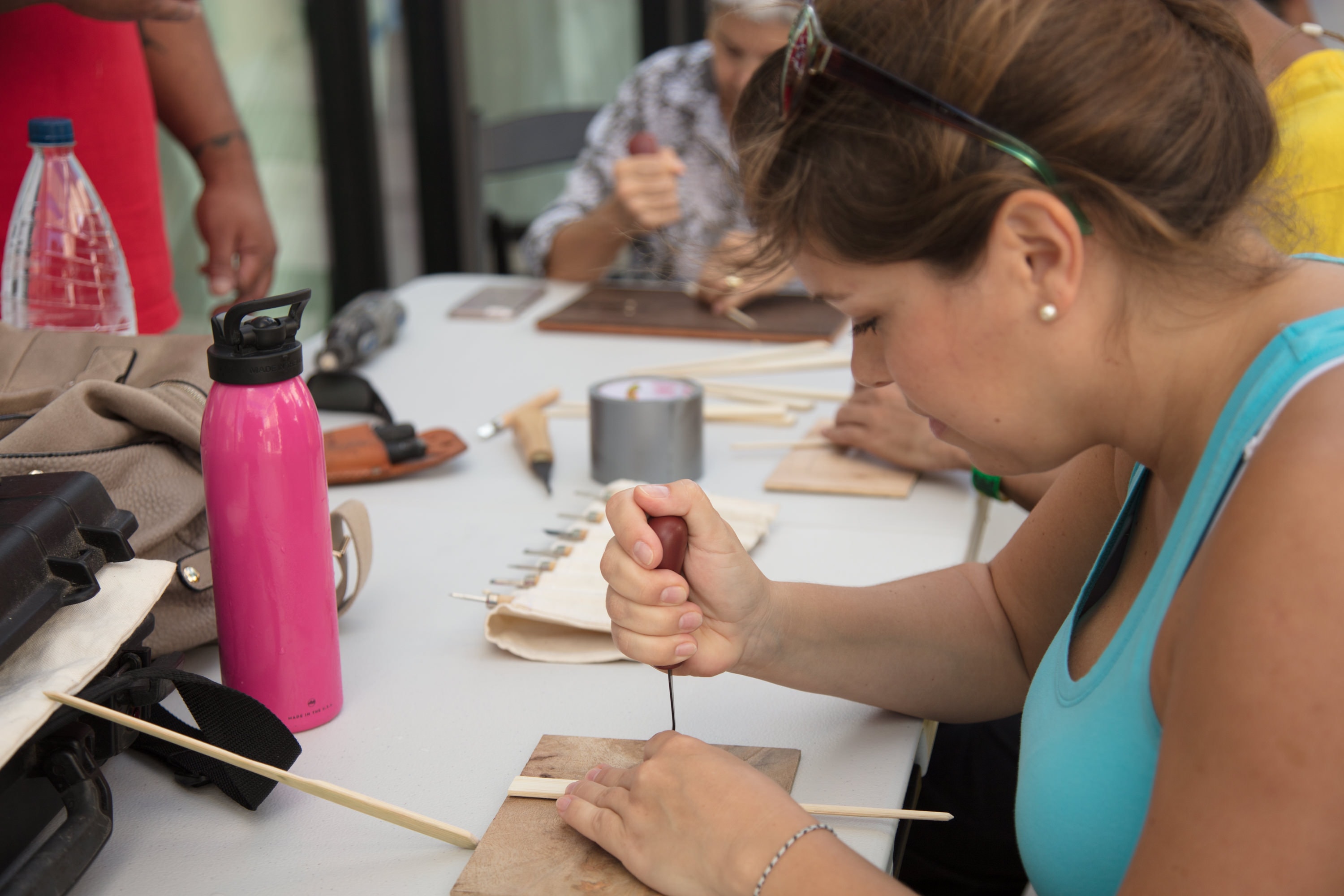 Girl threading needle at craft workshop