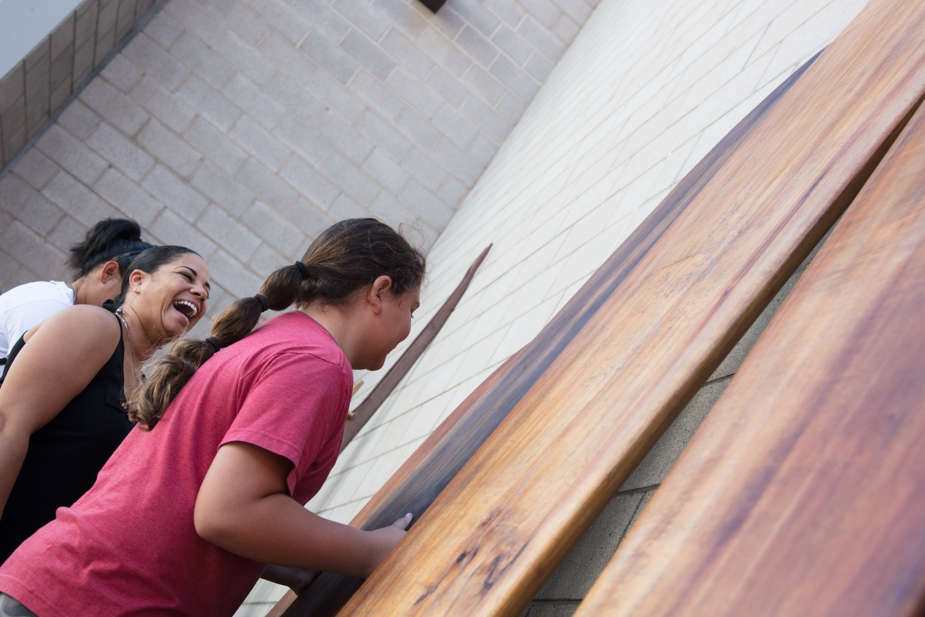 Two women laughing on wooden railing
