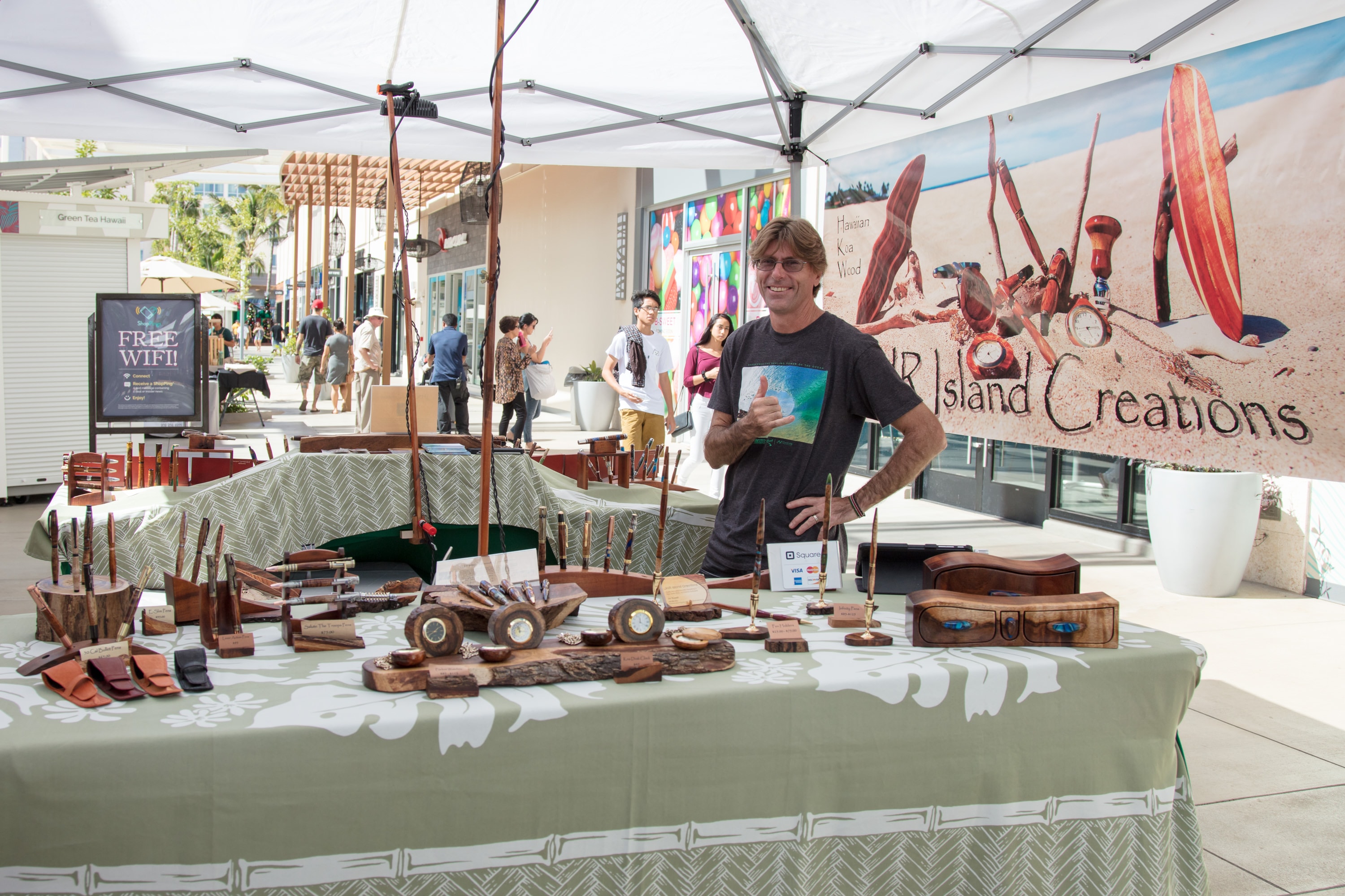 Artisan displaying wooden crafts at market booth