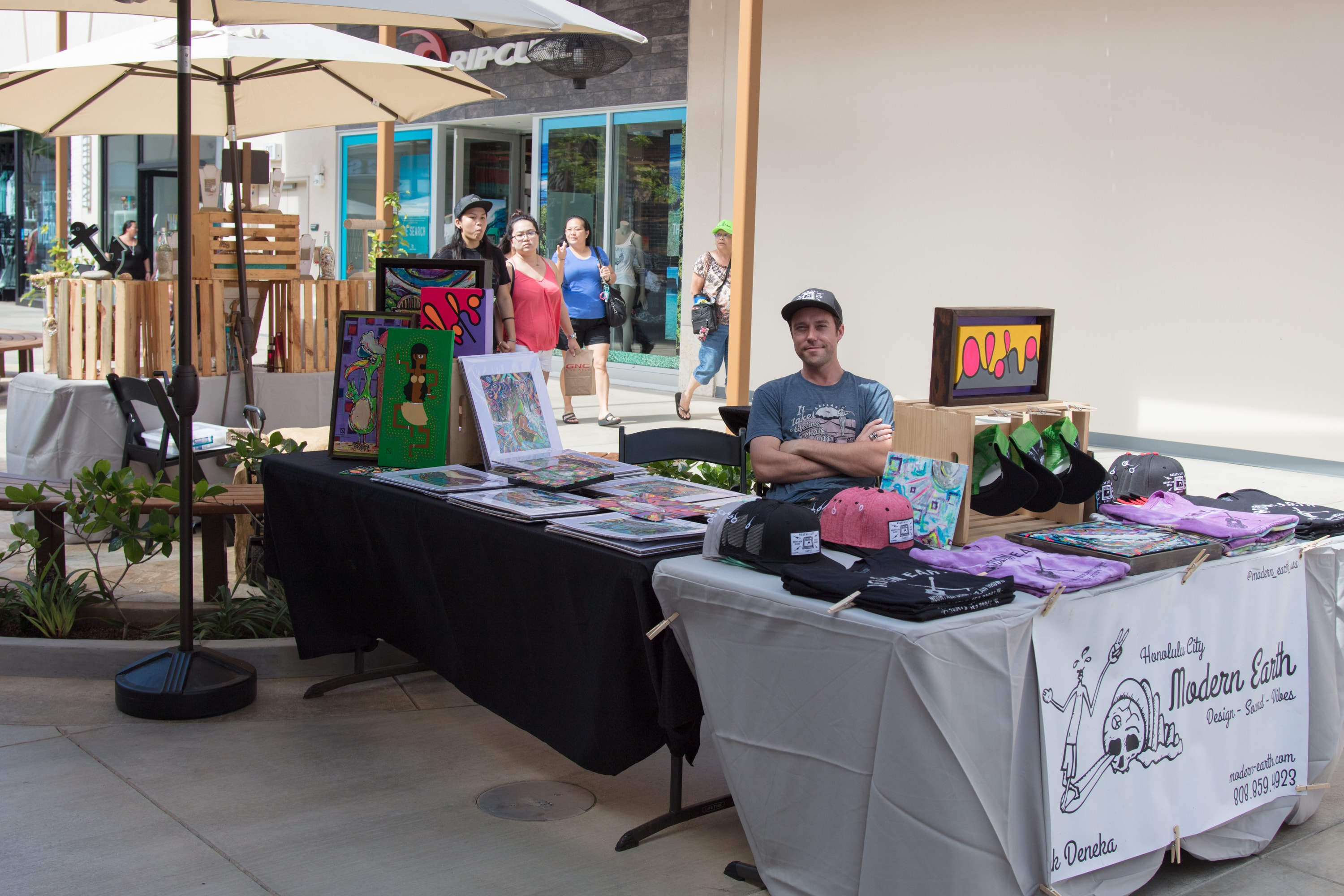 Artist selling artwork at outdoor market booth