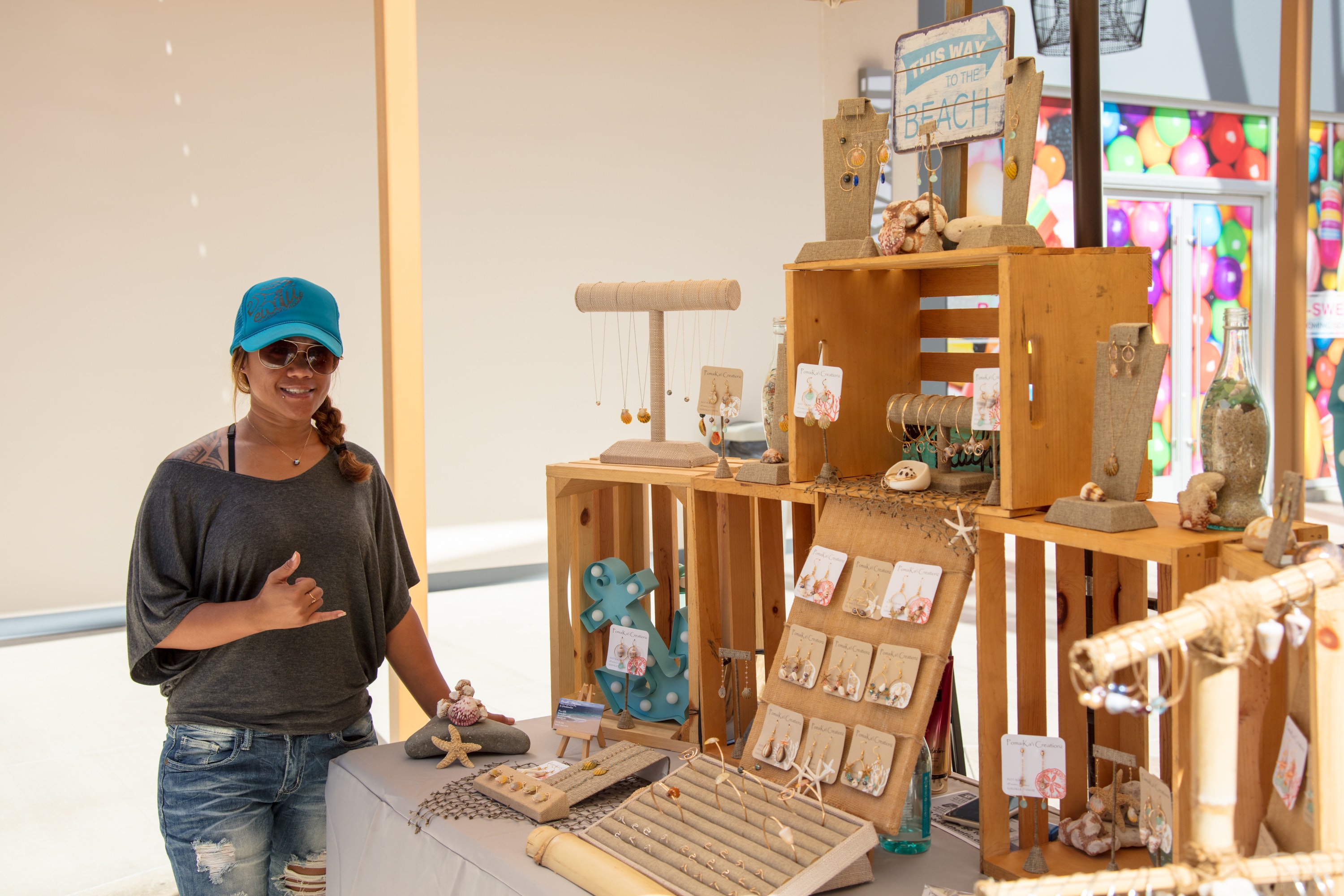 Woman displaying handmade beach jewelry display
