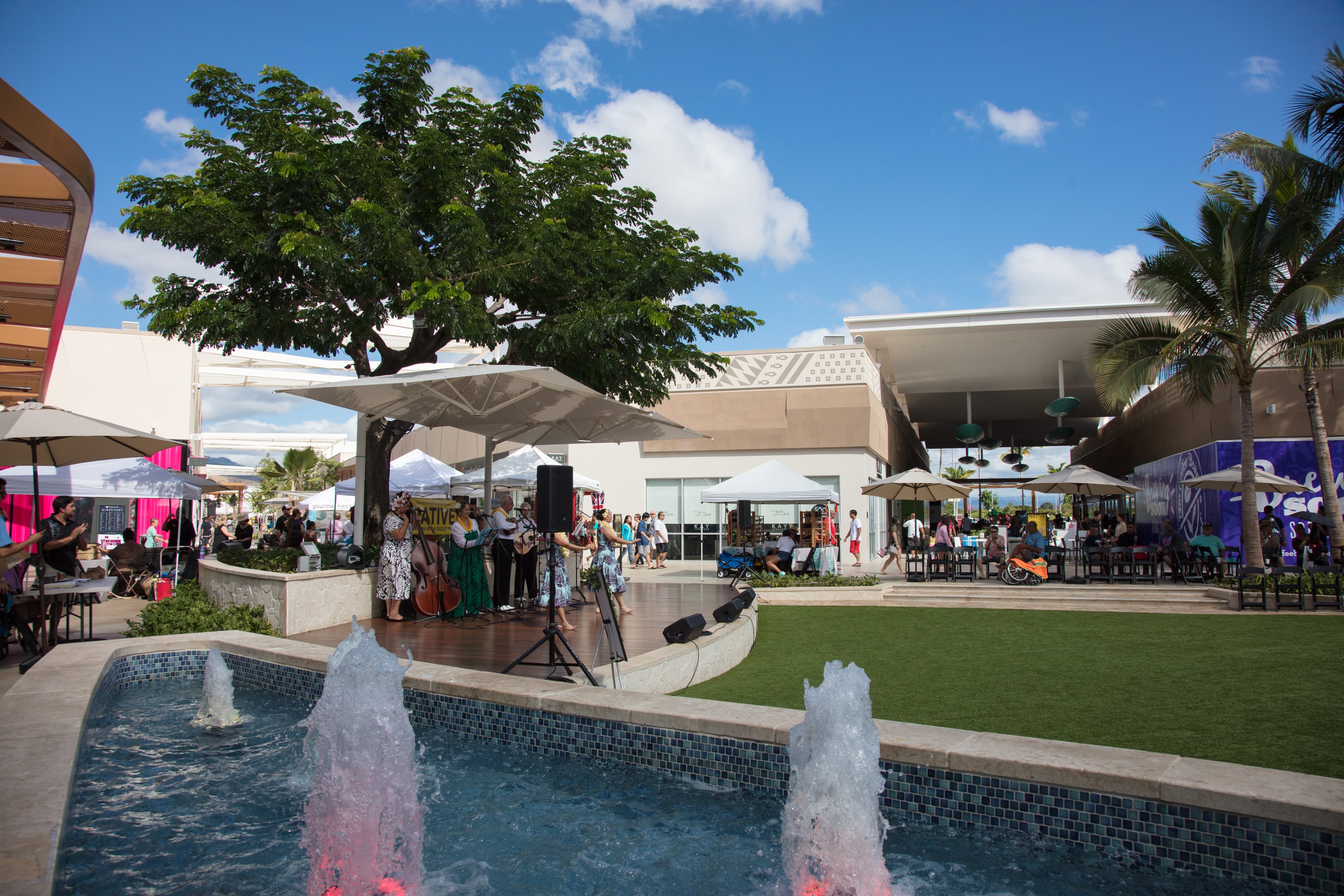 Outdoor plaza event with fountain and crowd