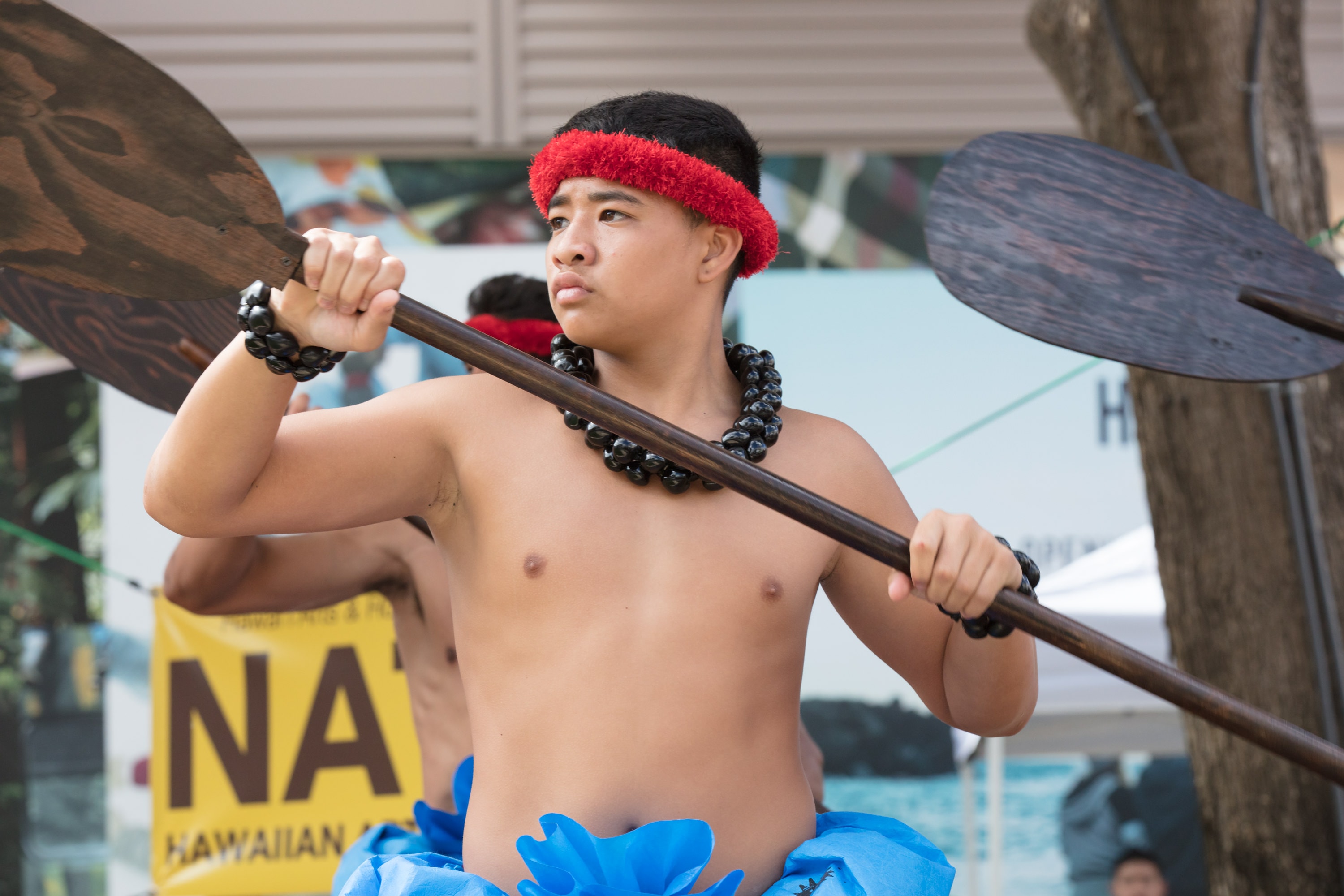 Young man holding outrigger canoe paddle