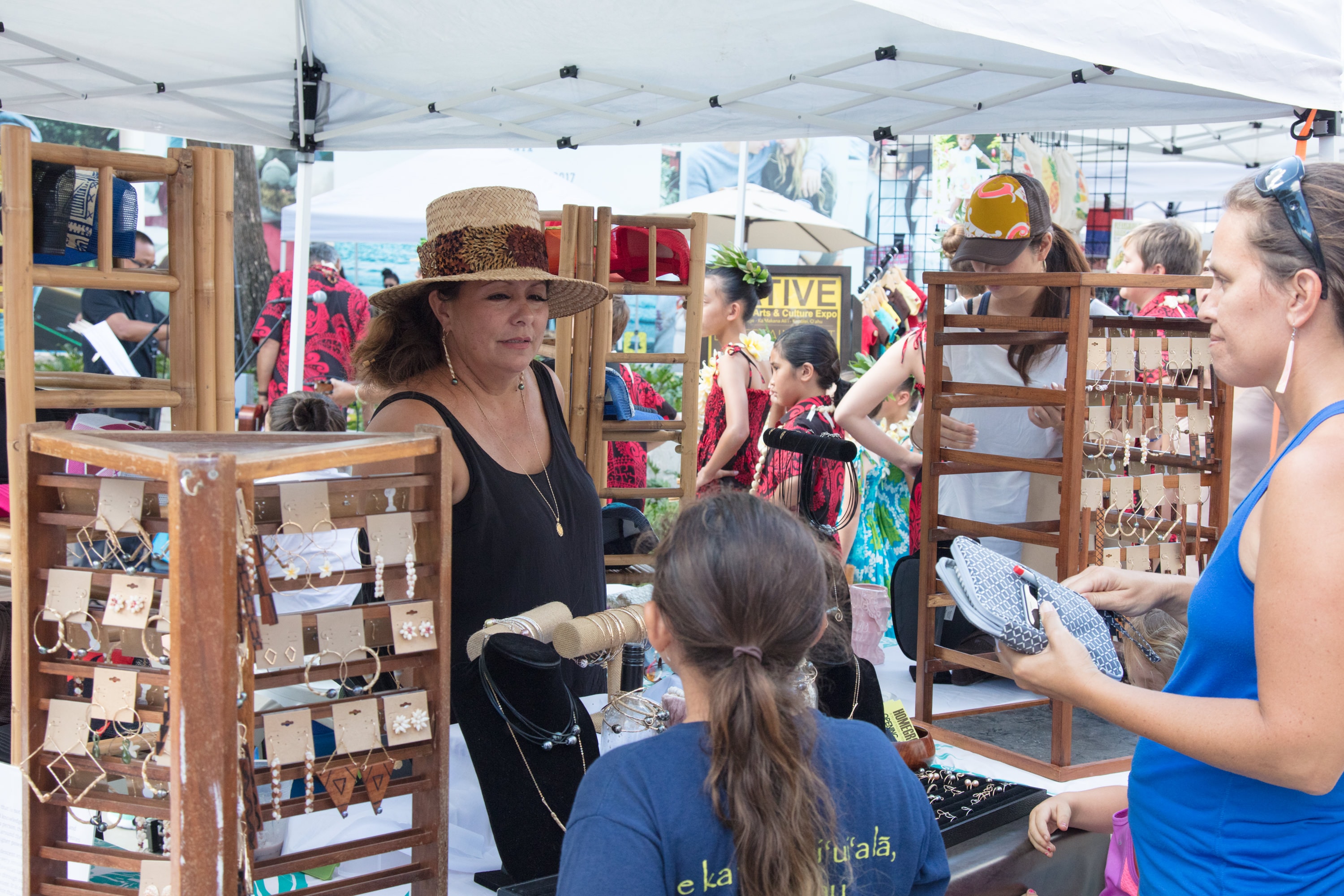 Vendor selling jewelry at outdoor market booth