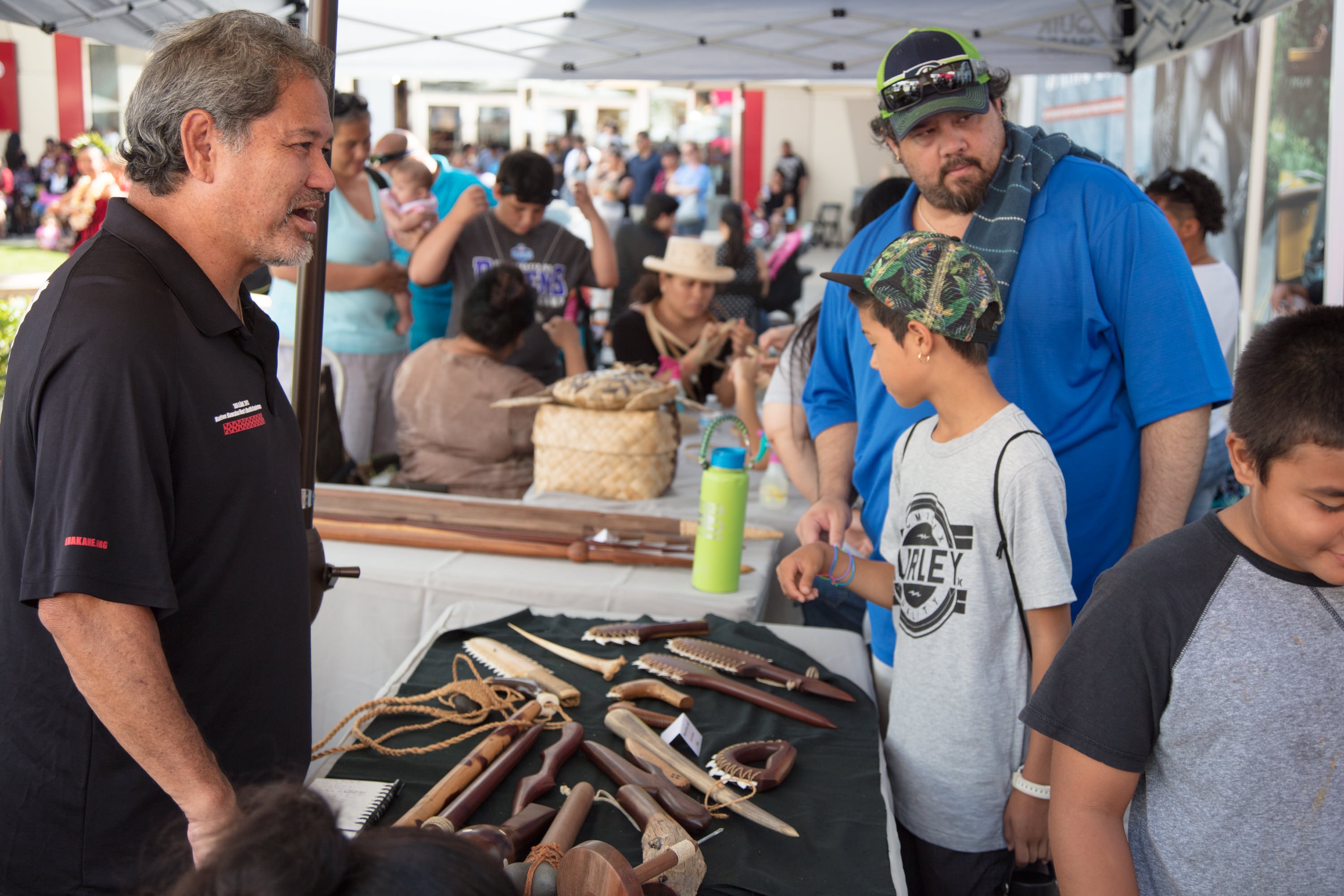 Man demonstrating traditional tools to children