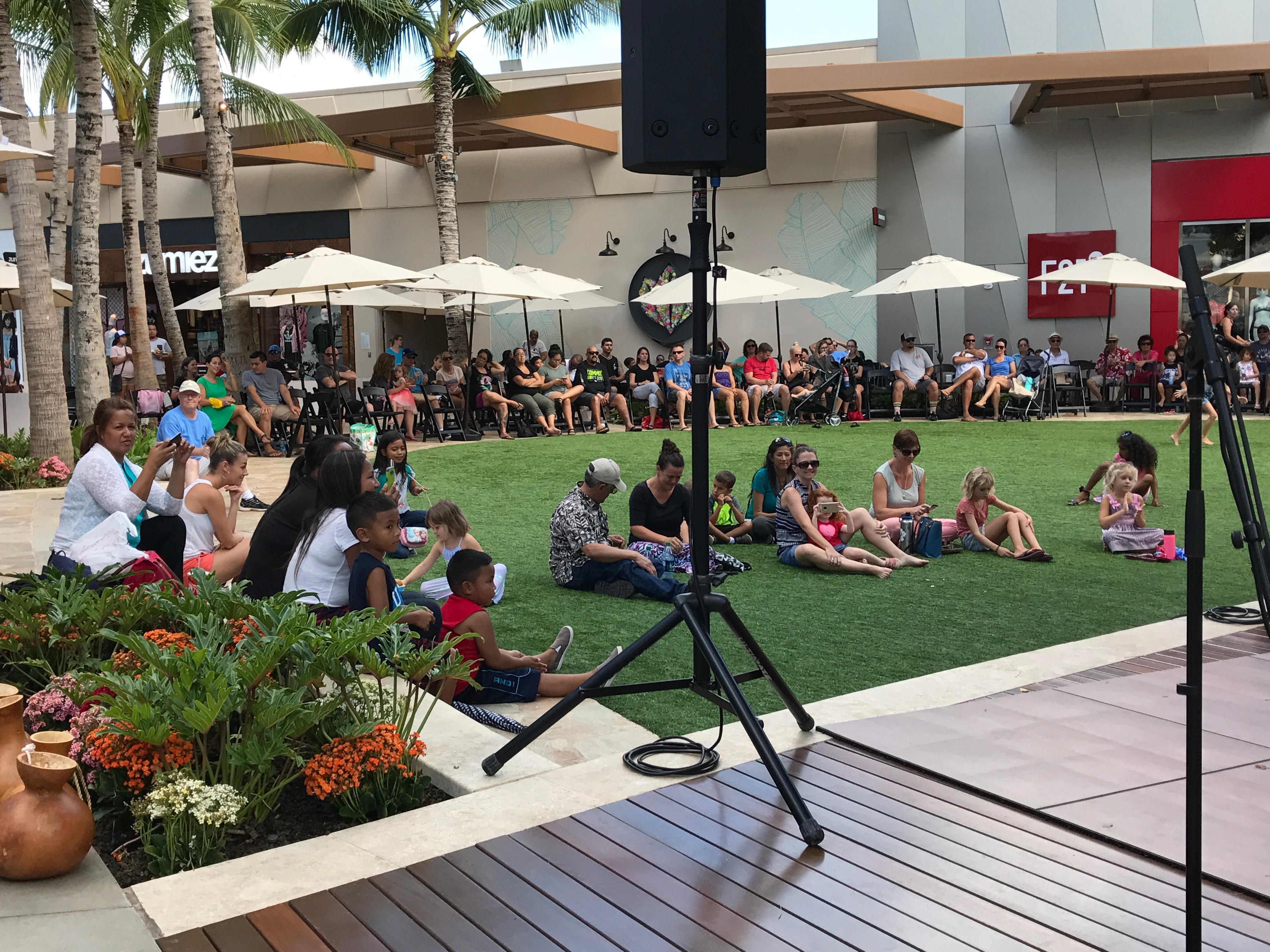Outdoor event crowd sitting on grass lawn