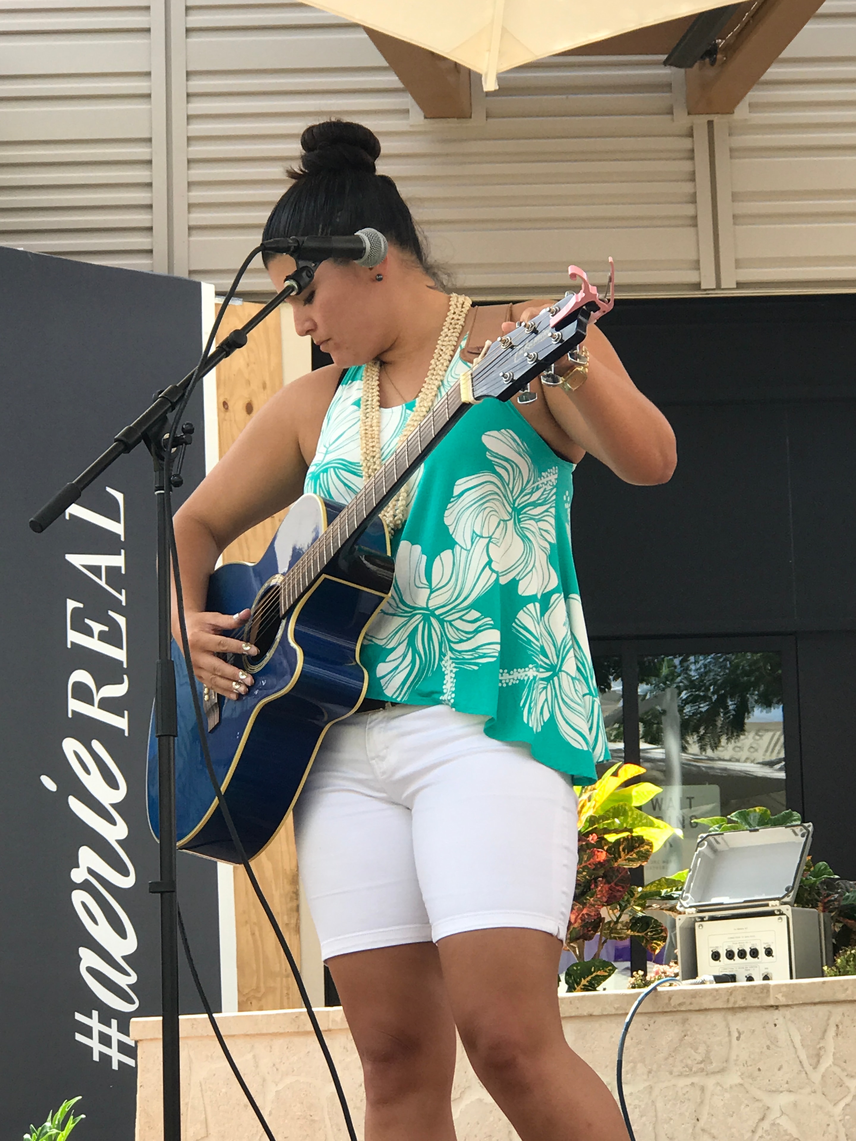 Woman singing playing acoustic guitar outdoors